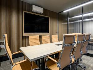 a conference room with a wooden table and chairs at Menlyn Mix in Pretoria