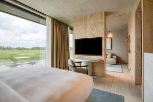 a hotel room with a large bed and a television at Radisson Collection The National Hotel, Brussels in Zaventem