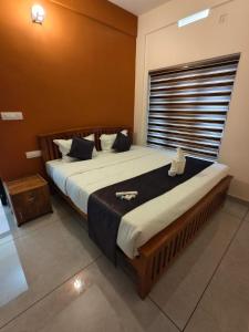 a bedroom with a large bed with a large window at Havens Nature Homestay in Ambalavayal