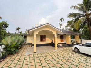 a house with a car parked in front of it at Havens Nature Homestay in Ambalavayal
