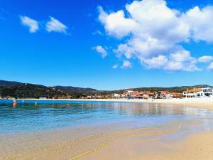 a beach with the ocean and buildings in the background at Eden's Garden luxury Studio in Kalamitsi