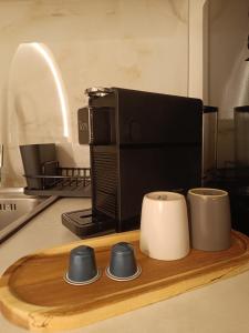 a kitchen counter with a coffee maker and three cups at Eden's Garden luxury Studio in Kalamitsi
