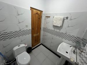 a white bathroom with a toilet and a sink at cloudrestskardu in Skardu +23 photos