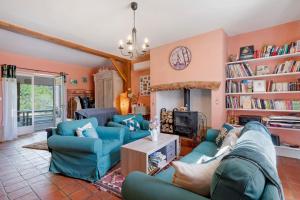 ein Wohnzimmer mit blauen Sofas und Bücherregalen in der Unterkunft Chambres D'hôtes Baladous in Montgaillard-de-Salies
