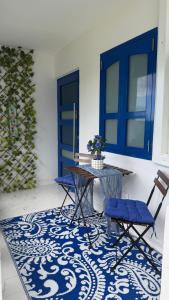 a patio with a table and chairs and a blue door at Private Oasis with Jacuzzi & Pool for Two in Ciales