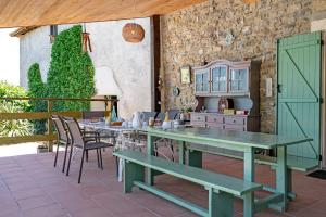 eine Terrasse mit Tisch, Stühlen und einem Schrank in der Unterkunft Chambres D'hôtes Baladous in Montgaillard-de-Salies