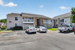 two cars parked in a parking lot in front of a building at Spacious 2BR stay with updated interiors in Lenexa