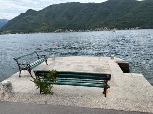 a bench sitting on a dock near a body of water at Apartment Forteca Lux in Perast