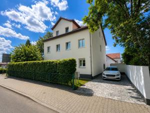 a white house with a car parked in front of it at Mevida Ferienwohnung in Borna