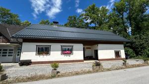 a house with a black roof and two windows at Apartments Vila Ančka in Tržič