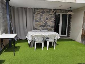 a room with a table and chairs on green grass at Studio avec terrasse et parking privé in Château-Arnoux-Saint-Auban +1 photo