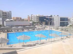 a large swimming pool with umbrellas on top of it at Modern 3-BR gated Sheikh Zayed Compound Open Views in Sheikh Zayed