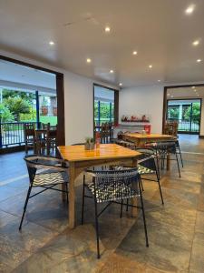 a dining room with tables and chairs and windows at Hotel Campestre Santa Lucia in Montenegro