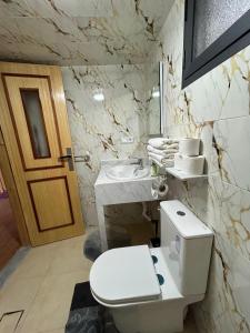 a white bathroom with a toilet and a sink at DAR Assoul in Khenifra +37 photos
