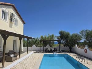 a villa with a swimming pool and a house at Villa Mari in Makris Gialos