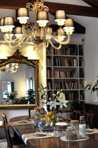 mesa de comedor con lámpara de araña y espejo en Casa Colleoni, en Venecia