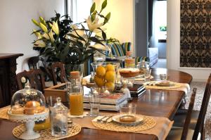 una mesa de comedor con comida y naranjas. en Casa Colleoni, en Venecia