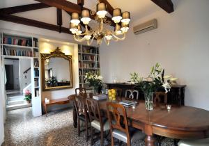 a dining room with a wooden table and a chandelier at Casa Colleoni in Venice