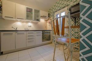 a kitchen with white cabinets and a wooden chair at La met au loup in Charmont-sous-Barbuise