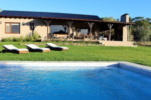 a house with a swimming pool in front of a house at Casa Retama Boutique in Sierra de la Ventana