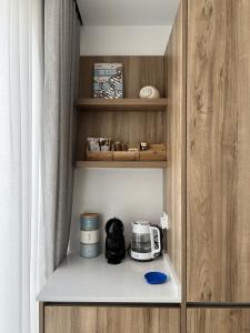 a cupboard with a coffee maker and a toaster at Seaview Marsaxlokk Apartment Eye of Osiris in Marsaxlokk