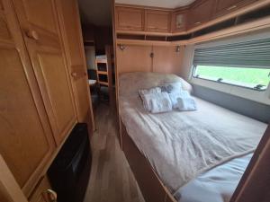 a small bedroom with a bed in an rv at Camping Obłazek in Piwniczna-Zdrój