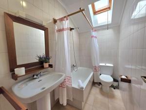 a bathroom with a sink and a toilet and a mirror at Apartamento Viento y Marea 20811 in Argoños +8 photos