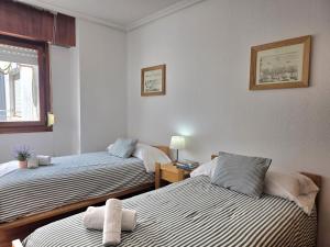 a bedroom with two beds and a window at Apartamento Viento y Marea 20811 in Argoños