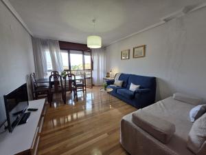 a living room and dining room with a blue couch at Apartamento Viento y Marea 20811 in Argoños