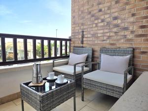two chairs and a coffee table on a balcony at Apartamento Viento y Marea 20811 in Argoños