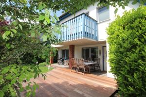 a house with a deck with a table and chairs at Ferienhaus Uli in Wustrow
