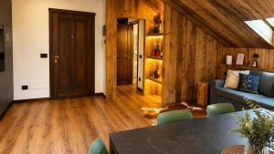 a living room with a blue couch and wooden floors at Appartamento Arisch in Aprica +13 photos