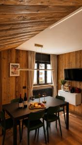 a dining room with a black table and chairs at Appartamento Arisch in Aprica