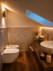 a bathroom with a white toilet and a sink at Appartamento Arisch in Aprica