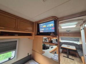 an rv with a tv in the middle of it at Camping Obłazek in Piwniczna-Zdrój +18 photos