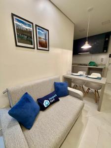 a living room with a couch with blue pillows on it at Studio Atalaia - C -308 - By Hospede Fácil in Brasília