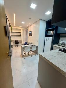 a kitchen with a counter and a table and chairs at Studio Atalaia - C -308 - By Hospede Fácil in Brasília