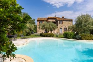 a large swimming pool in front of a house at Podere Il Pozzangone by Geco Vacation Rentals in Lucignano