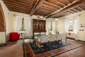 a dining room with a glass table and chairs at Podere Il Pozzangone by Geco Vacation Rentals in Lucignano