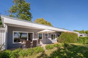 a small house with a patio and an umbrella at Boddenweite 3 in Born