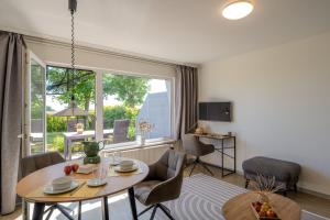 a living room with a table and a large window at Boddenweite 3 in Born