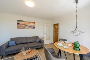 a living room with a couch and a table at Boddenweite 3 in Born +13 photos