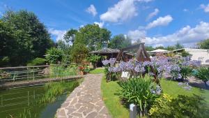 a garden with purple flowers next to a river at Pension Karin in Breitengüßbach