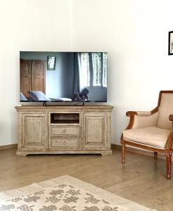a tv sitting on top of a wooden cabinet in a room at Mas des Prevots B&B in Noves