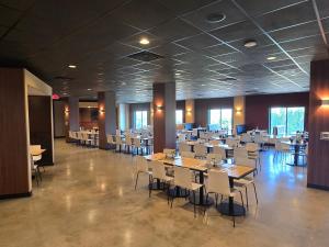 a dining room with tables and white chairs at Dutch Wonderland Inn in Lancaster