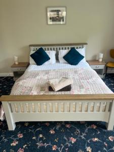 a bedroom with a large bed with blue pillows at The Holm in Canonbie