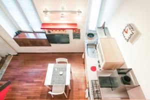 einen Blick über eine Küche mit einem Tisch und Stühlen in der Unterkunft Miniloft-Angy-Navigli in Mailand