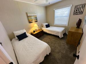 a bedroom with two beds and a sign on the wall at N6913- Heidaway (Formerly Devlin's Roost) in Nags Head