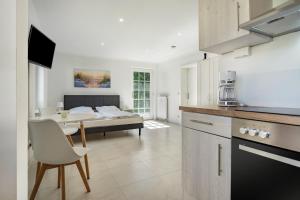 a kitchen and living room with a table and a bed at Feriendomizil Putbus - Nr. 3b in Putbus