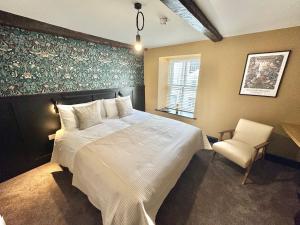 a bedroom with a white bed and a chair at Charlie's Quarters Brampton Self Check-In Rooms in Brampton +10 photos